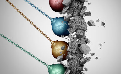 Colorful wrecking balls breaking a concrete wall, symbolizing innovation and change.
