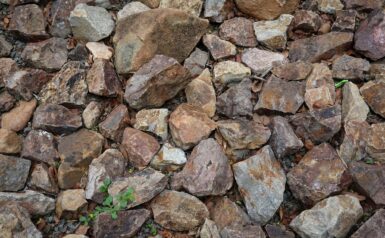 Close-up of various natural mineral rocks in earthy tones, representing raw mineral materials.